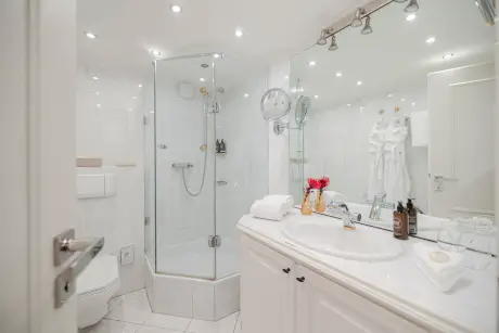Modernes Badezimmer mit Glasdusche, eleganter Waschbeckenecke und stilvollen Accessoires.