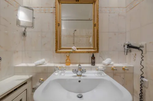 Elegantes Badezimmer im Hotel Stadt Hamburg mit Waschbecken, Spiegel und luxuriösen Annehmlichkeiten.