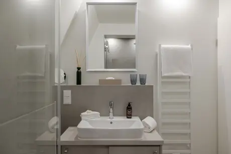 Modernes Badezimmer mit Waschbecken, Spiegel und Handtuchhalter in der Hotel Stadt Hamburg.