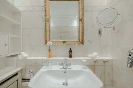 Elegantes Marmorbadezimmer mit einem stilvollen Waschbecken und einem dekorativen Spiegel.