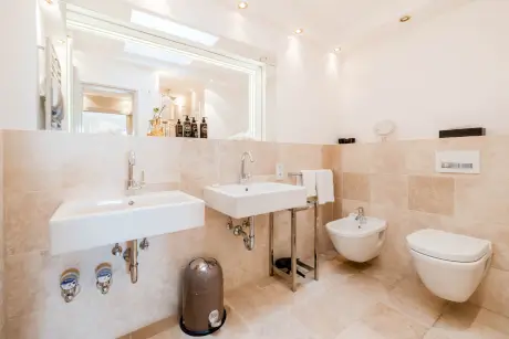 Elegante Badezimmermerkmale im Hotel Stadt Hamburg, einschließlich Waschbecken, Bidet und modernen Toiletten.