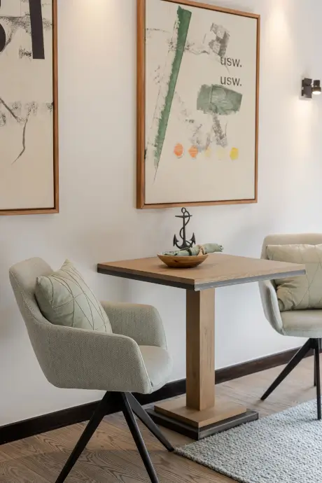 Moderner Esstisch mit stilvollen Stühlen, Holztisch und einzigartiger Wandkunst im Hotel Stadt Hamburg.