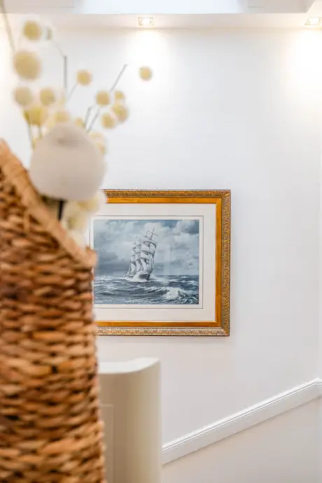 Maritime Gemälde und dekorativer Korb im Hotel Stadt Hamburg in Kampen.