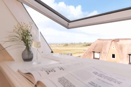 Genießen Sie einen gemütlichen Blick auf die Landschaft mit Blumen, einem Getränk und einer Zeitung.