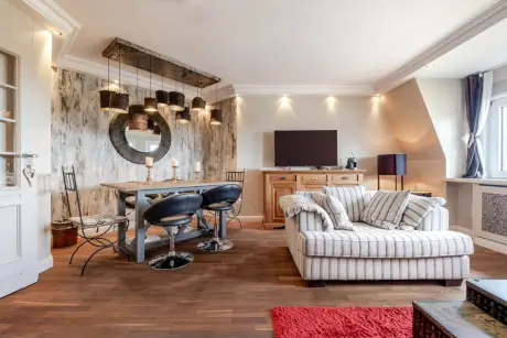 Eleganter Essbereich mit stilvollem Tisch, Stühlen und gemütlichem Sofa in einem Hotelzimmer.
