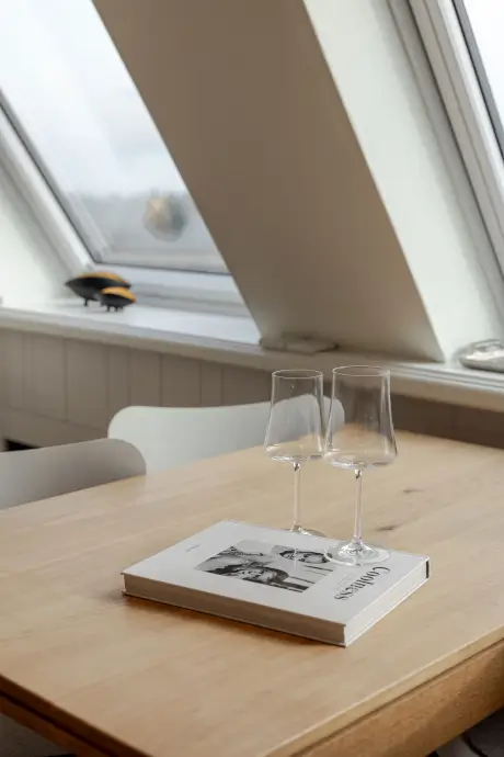 Gemütliches Hotelzimmer im 12.18. Hotel Stadt Hamburg mit Weingläsern und einem Chanel-Buch.