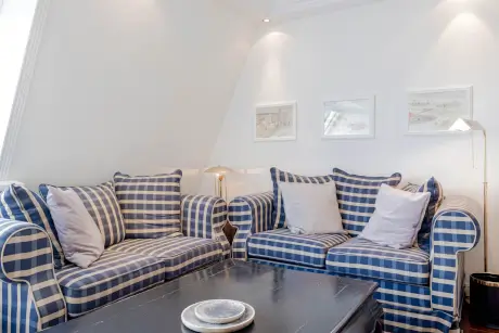 Gemütliche Sitzecke mit gestreiften Sofas in einem Hotelzimmer in Kampen, Sylt.