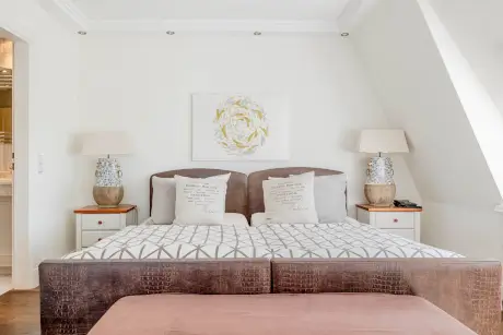 Elegantes Hotelzimmer mit einem großen Bett und stilvollem Dekor im 12.18. Hotel Stadt Hamburg.