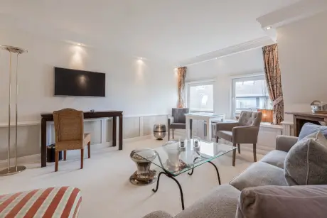 Luxuriöse Hotelsuite mit modernen Möbeln und einem Flachbildfernseher.