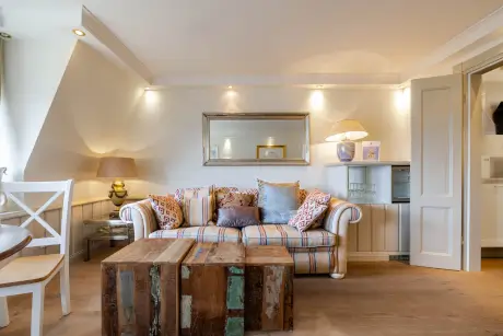 Gemütliches Hotelzimmer im Hotel Stadt Hamburg mit Sofa, Holztisch und angenehmem Licht.