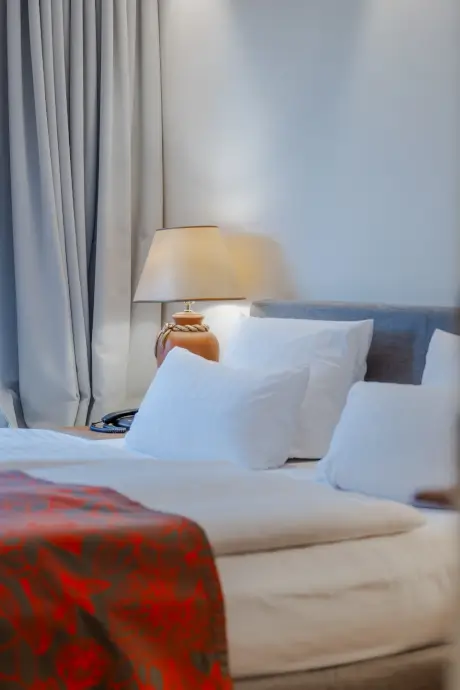 Gemütliches Hotelzimmer im 12.18 Hotel Stadt Hamburg mit einem Bett und einer Lampe.