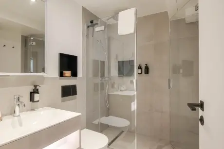 Modernes Hotelbad mit begehbarer Dusche und eleganten Armaturen im 12.18. Hotel Stadt Hamburg.