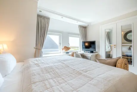 Gemütliches Hotelzimmer mit Bett, Fenster, Fernseher und Stuhl im 12.18 Hotel Stadt Hamburg GmbH, Kampen.