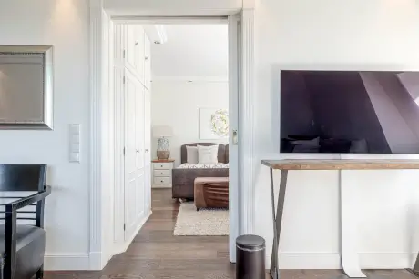 Modernes Hotelzimmer mit Fernseher, Tür und gemütlichem Bett.