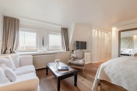 Elegantes Hotelzimmer mit Sofa, Tisch und Fernseher im Hotel Stadt Hamburg, Kampen, Sylt.
