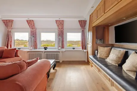 Stylisches Hotelzimmer mit großen Fenstern und komfortablen Möbeln im Hotel Stadt Hamburg, Kampen.