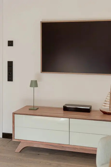 Moderne Hotelzimmer mit Tischlampe, Fernseher und dekorativem Boot.
