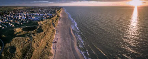 Luftaufnahme vom Kampen Strand bei Sonnenuntergang, der die natürliche Schönheit der Küste zeigt.