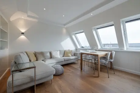 Stilvolles modernes Apartment mit Sofa und Essbereich, ideal zur Entspannung im 12.18 Hotel Stadt Hamburg.