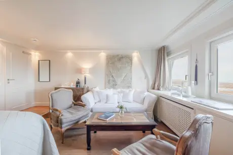 Modernes Zimmer im 12.18. Hotel Stadt Hamburg mit Sofa und Blick auf die Landschaft.