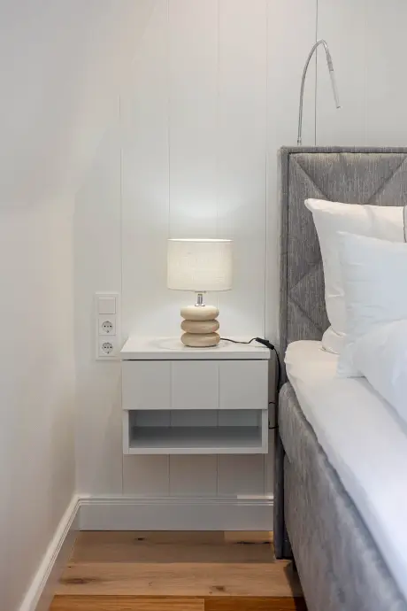 Modernes Schlafzimmer mit Nachttisch und Lampe in der Hotel Stadt Hamburg.