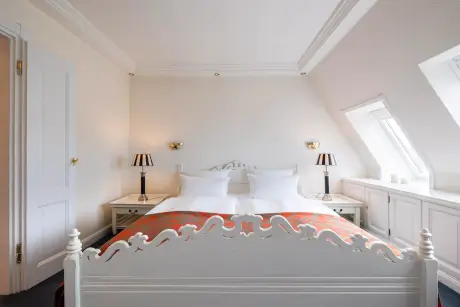 Elegantes Schlafzimmer mit bequemen Bett und stilvollen Nachttischlampen.