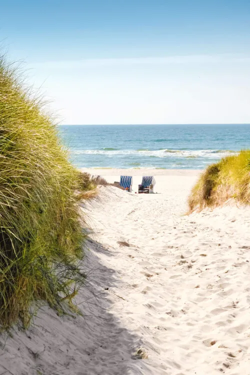 Malerscher Strandweg zum Ozean mit zwei Strandstühlen, ideal für Gäste des Hotel Stadt Hamburg.