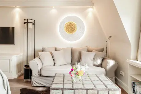 Gemütliches Wohnambiente mit Sofa, Tisch und dekorativer Wandbeleuchtung im Hotel Stadt Hamburg.
